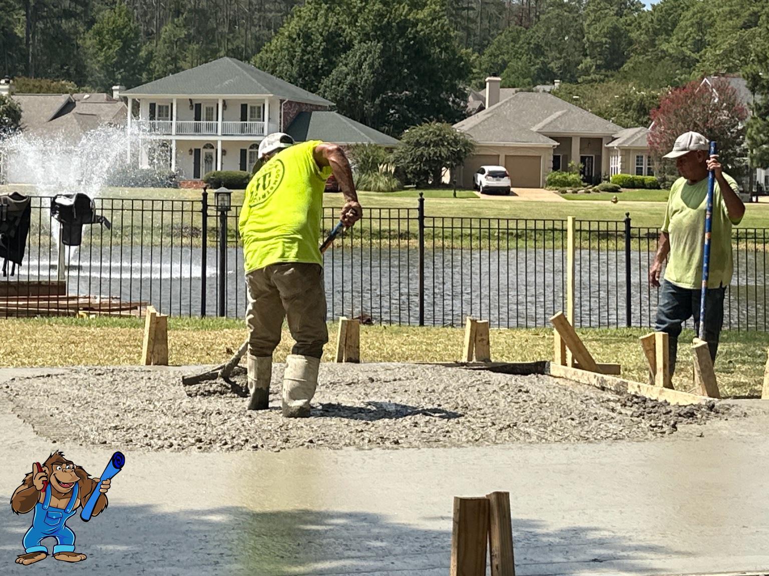 Workers pouring and finishing concrete slab construction for Gorilla Building project